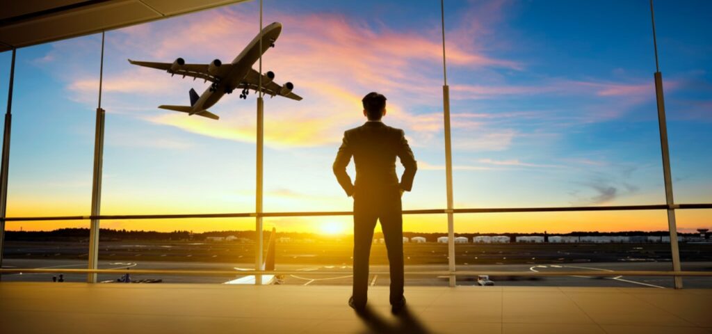 man watching plane take-off in the sunset