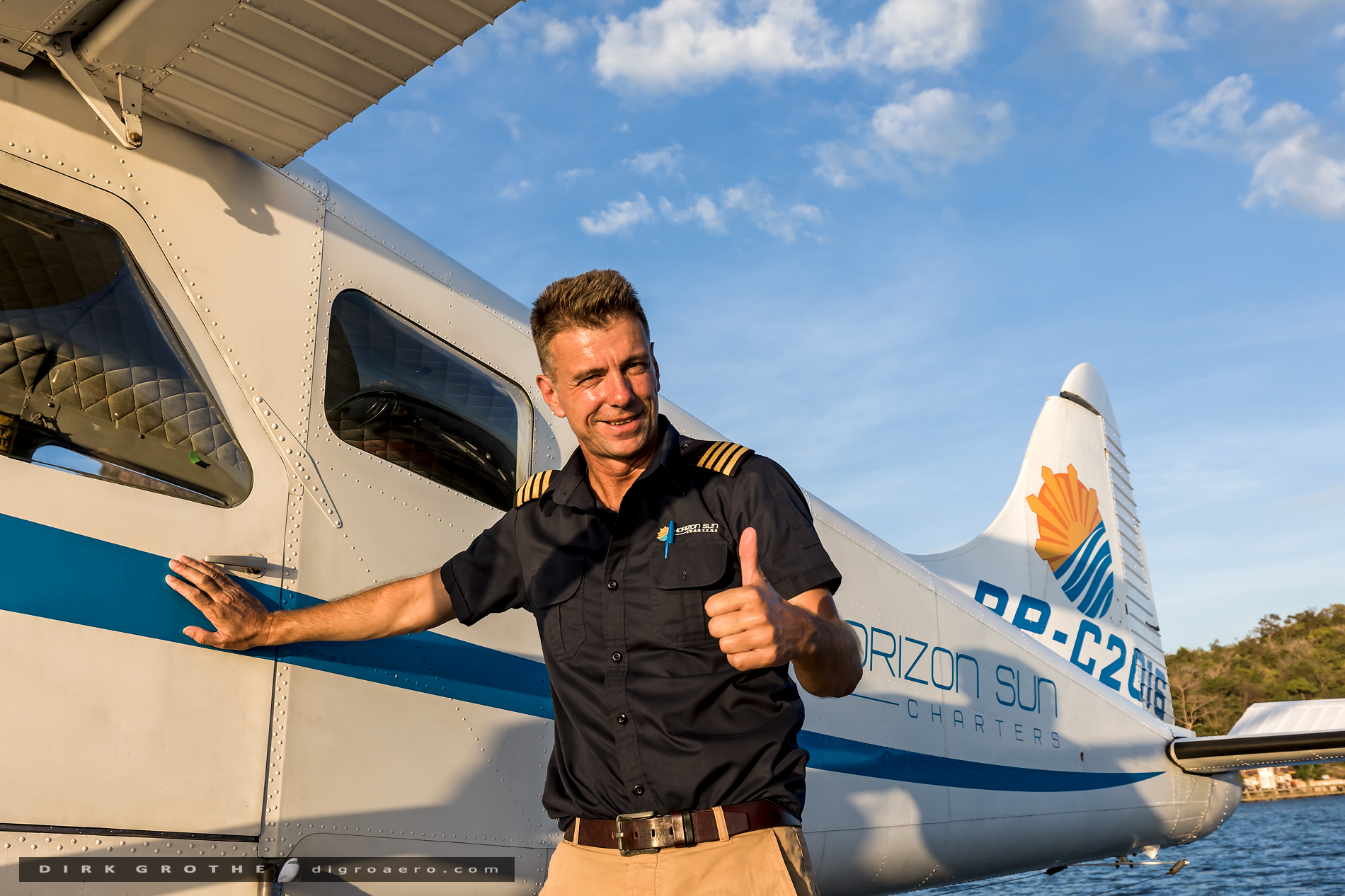 Pilot giving thumbs up beside the seaplane